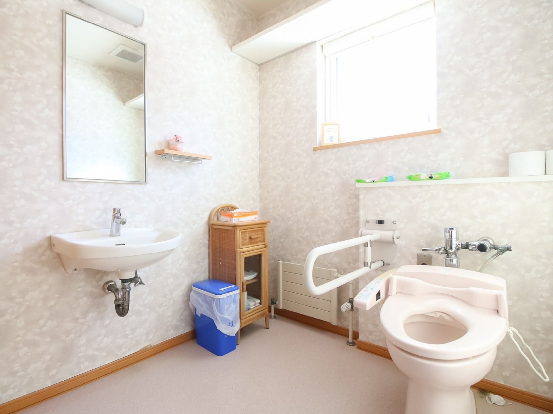 広いスペースに洗浄機能付きトイレがあり、すぐ隣には洗面台が配置してある。トイレの脇には可動式手すりが設置してある。