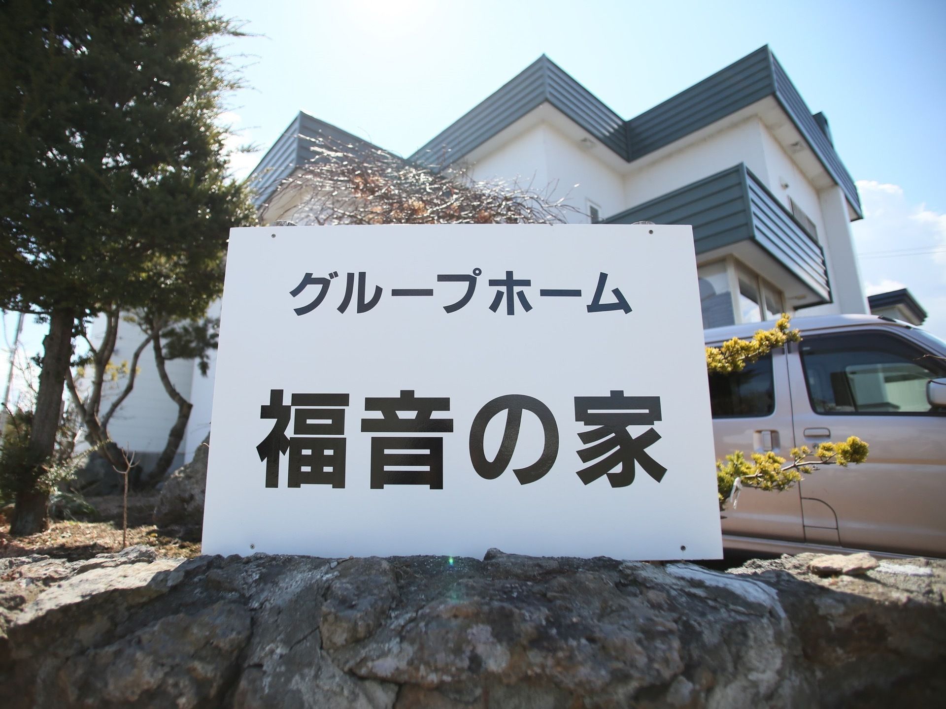 敷地内は岩の塀で囲われ、その一角に施設名が記載された看板が設置されている。白い板にシンプルに黒い字で書かれている。