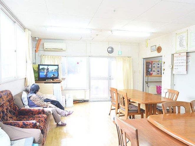 木製のダイニングテーブルにはいすがセットされ、大きな窓から日差しが降り注ぐ明るい食堂となっている。