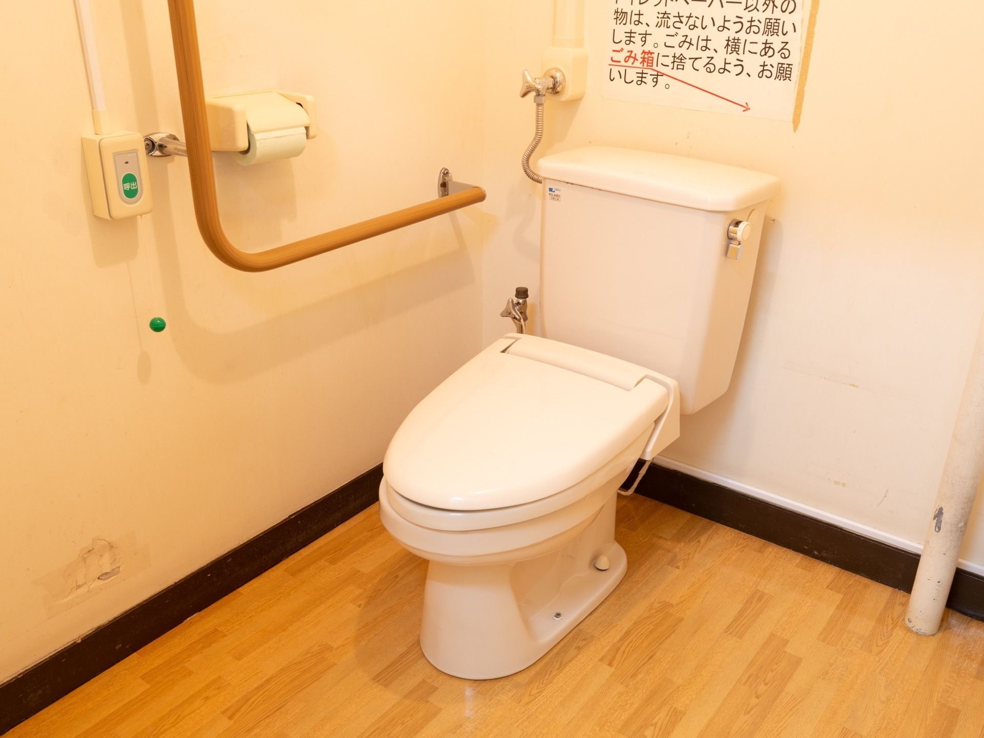 洋式便器が一据ある。便器には温水洗浄便座が設置されている。壁には使用時の注意書きが貼られている。呼出ボタンが設けられている。