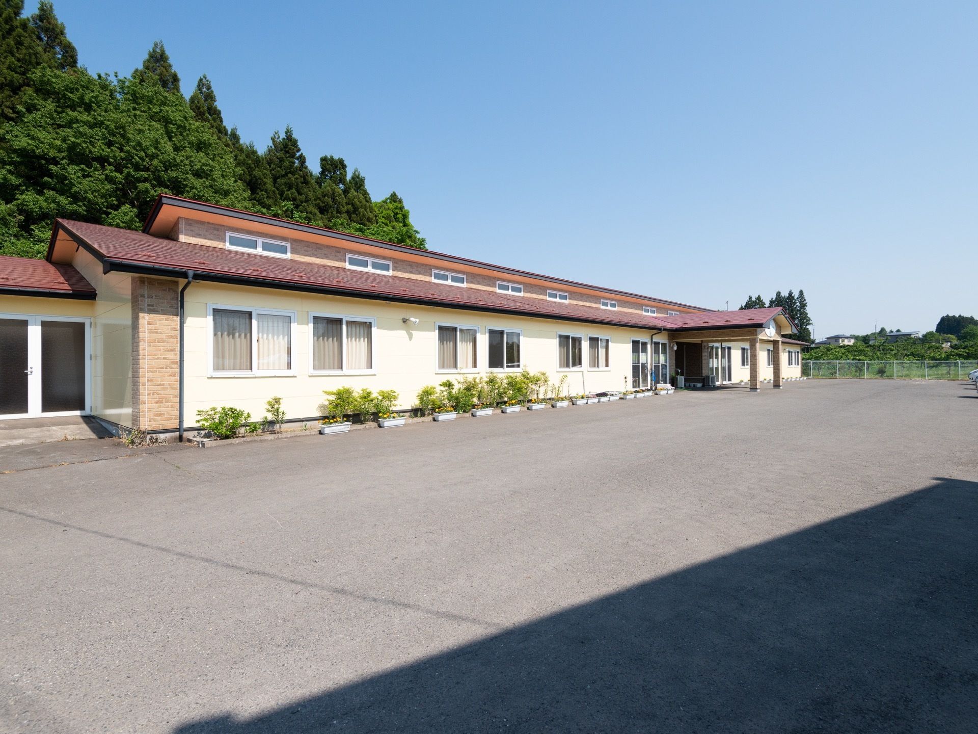 中央部に玄関がある、横に長い構造の施設である。天窓が多く並んで設置されている。広い敷地に立地している。