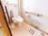 入口が引き戸になったトイレの図である。温水洗浄便座が取り付けられている。壁にはヒーターが設置されている。
