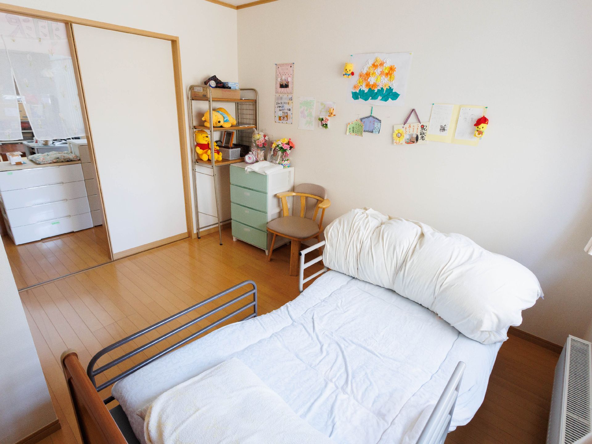 車いすに乗った男性とその人に話しかけている女性。家族で話している様子を写した写真