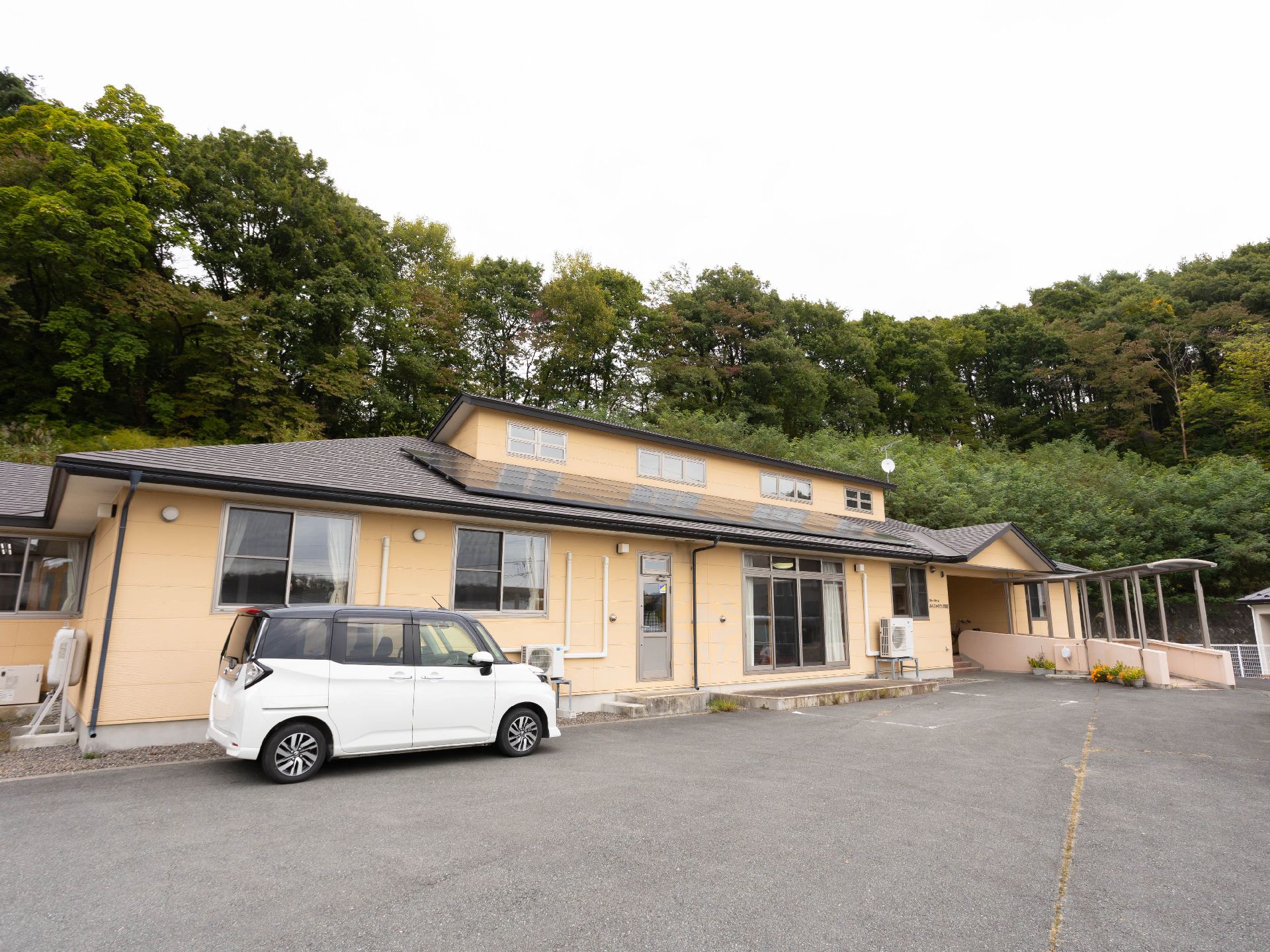 黄色を基調とした地上階１階建ての外観のグループホーム