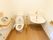 トイレの壁には花柄の飾りが貼られている。手洗い場の棚の上には消毒薬を完備。手すりが複数取り付けられている。