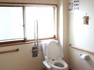 手すり付きのトイレの様子を写した写真。車いすでも入れるぐらいの広めのスペース