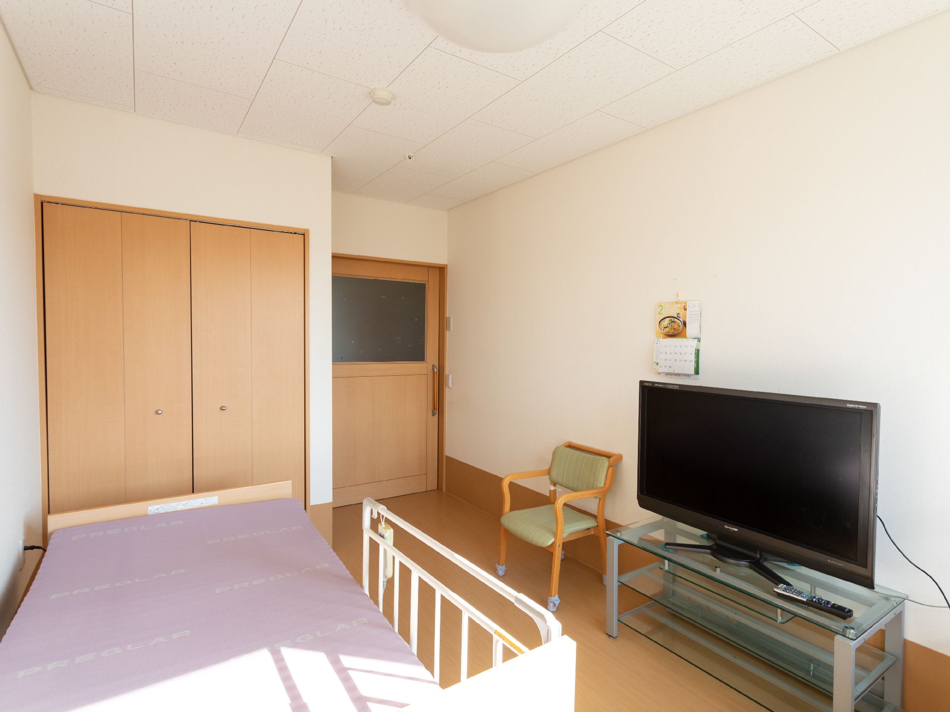 日差しが差し込み、介護ベッドや家具に日差しが当たっている居室