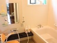 浴室に小さな浴槽とシャワーチェアがある様子。施設内に設置されている浴室