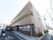 施設は３階建ての、シンプルなビルのような建物である。外壁は落ち着いた茶色が基調になっており、入口の前に駐車場がある。