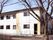 白をメインとした2階建ての建物。玄関部分には手すり付きのスロープが付いている。