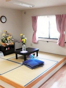 小上がりの畳スペース。季節の花が飾られ、座布団やテーブルも置かれている。