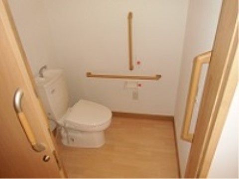 トイレの壁には赤い色の押しボタンがあり、緊急を要する場合にボタンを押して速やかに介護スタッフを呼ぶことが可能である。