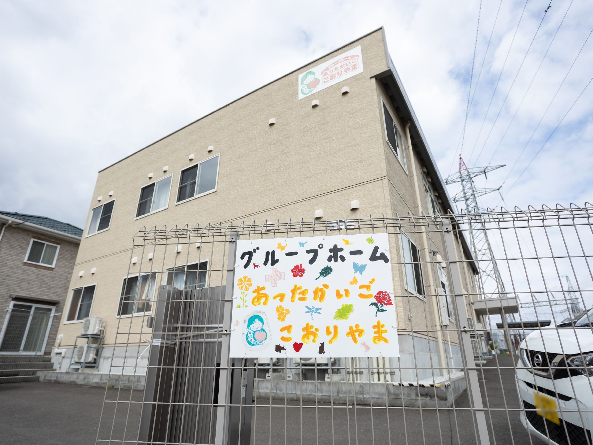 陽ざしの良い場所で何かを見つめている高齢女性と介護スタッフ。やわらかい表情のふたり