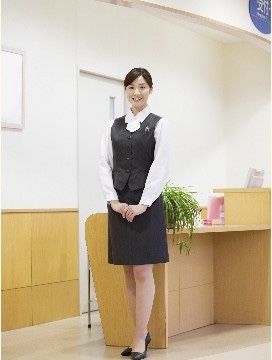 手を前で組んでにこやかに笑って立っている女性スタッフ