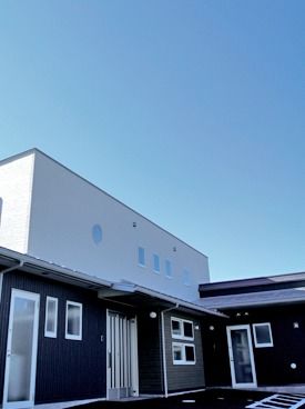 ツートンカラーの丈夫な建物が写っている写真。モダンデザインの施設の建物
