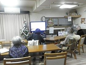 テレビが置いてあるリビングスペース。高齢者が集まってテレビを眺めている様子