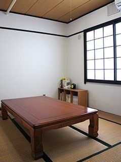 木製のテーブルが置いてある和室の様子。障子がある小さなリラックススペースの写真
