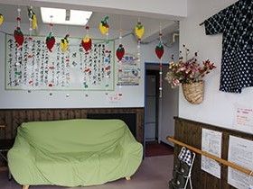 掲示物や飾りつけがある共有スペースの様子。ソファや手すりがある場所