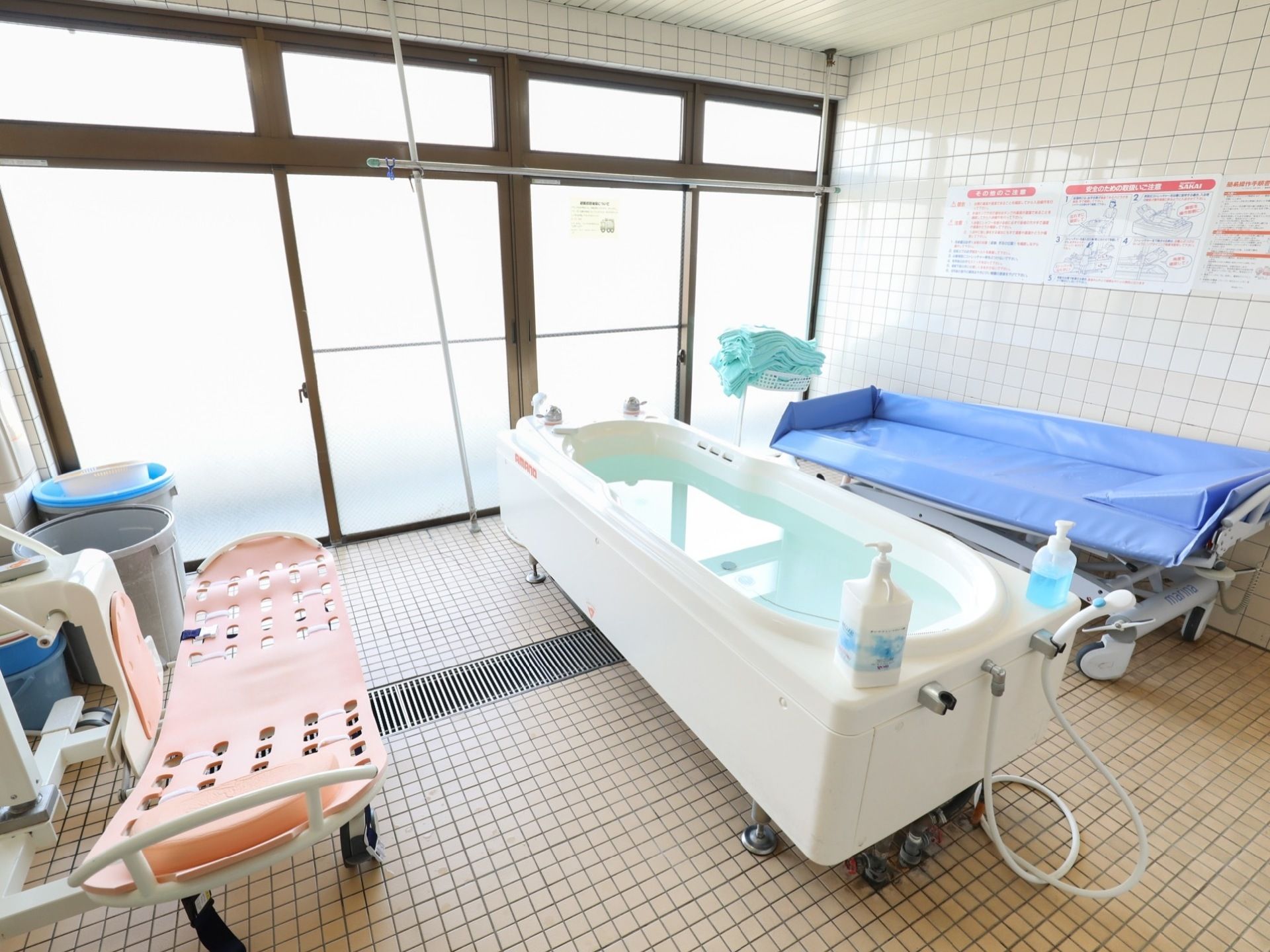 浴室中央にシャワー付きのお湯の張られた浴槽が設置されている。壁の一面には大きなすりガラスの窓が設けられている。