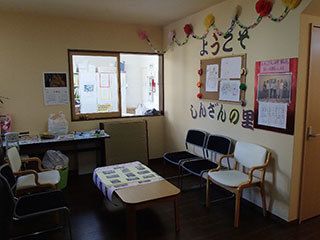 家庭的なサイズのリビングルーム。いすやテーブルが置いてある場所