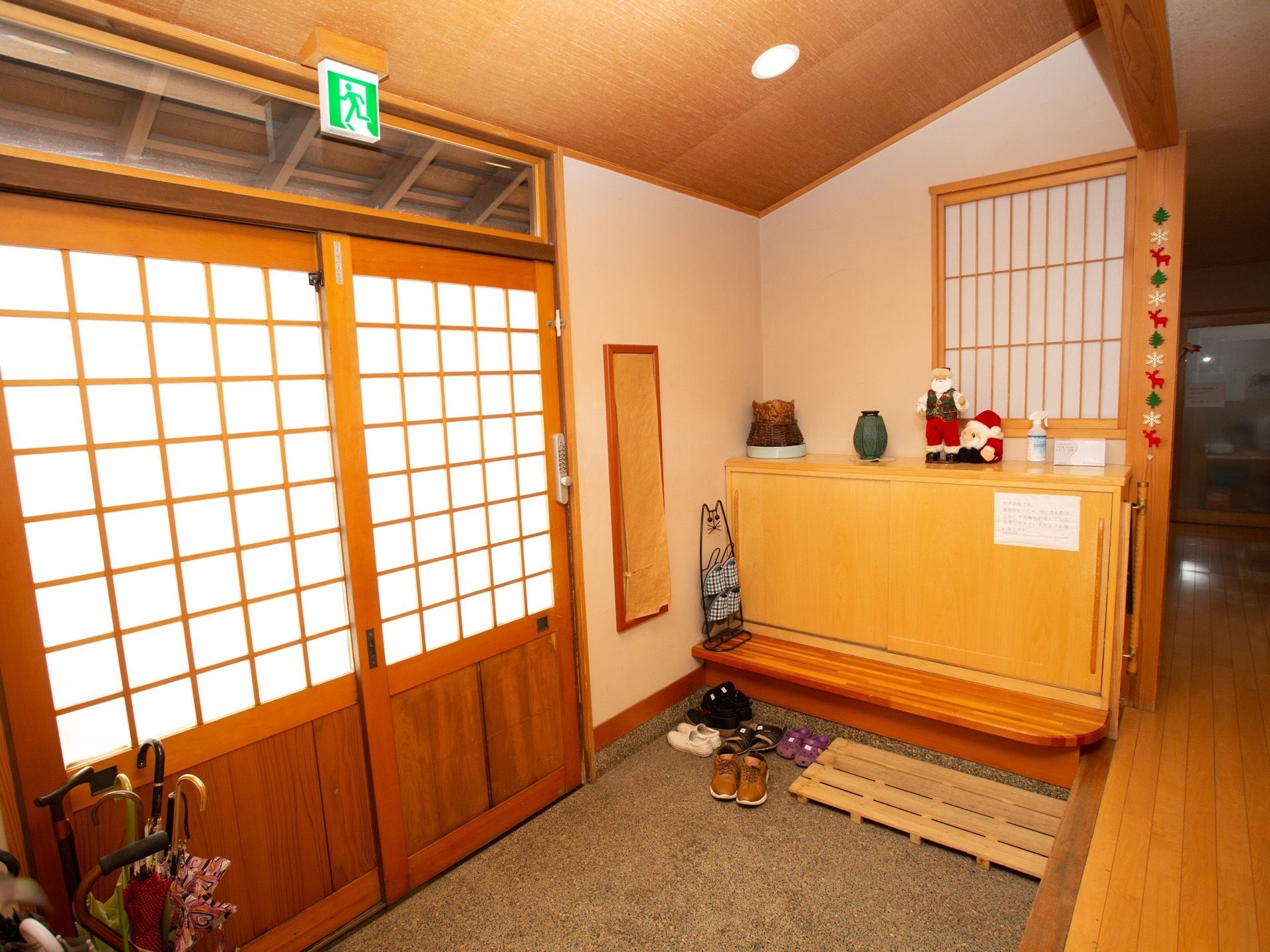 伝統的な和風建築の造りのエントランス。設置されたベンチに腰掛けて、安全に靴を履き替えられるようにしている。