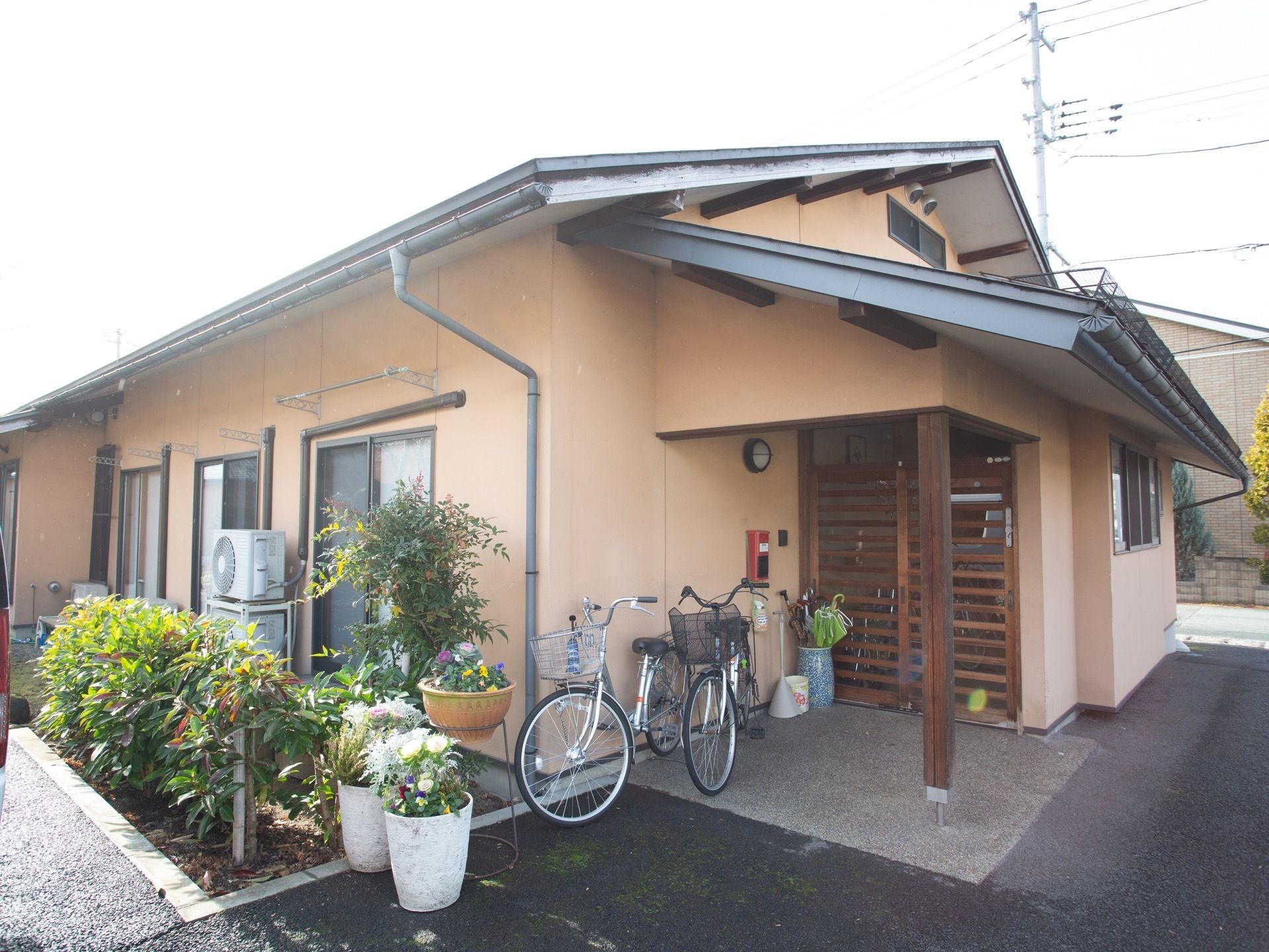 敷地内は、通路がきれいに舗装され、段差が少なく通行しやすくなっている。外壁はオレンジ色で、明るく柔らかい雰囲気。