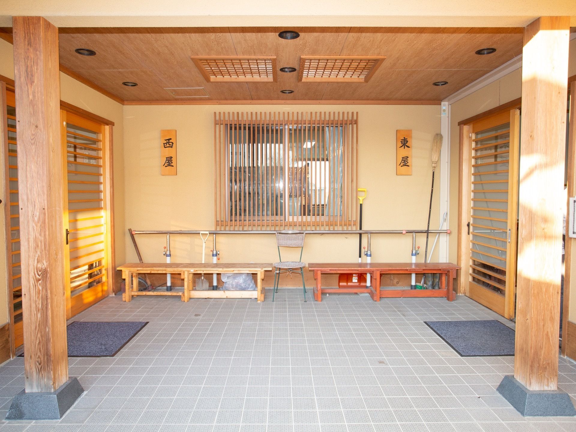 玄関には大きな屋根が設置されている。東屋と西屋に分かれて玄関が設けられている。玄関マットやベンチが置かれている。