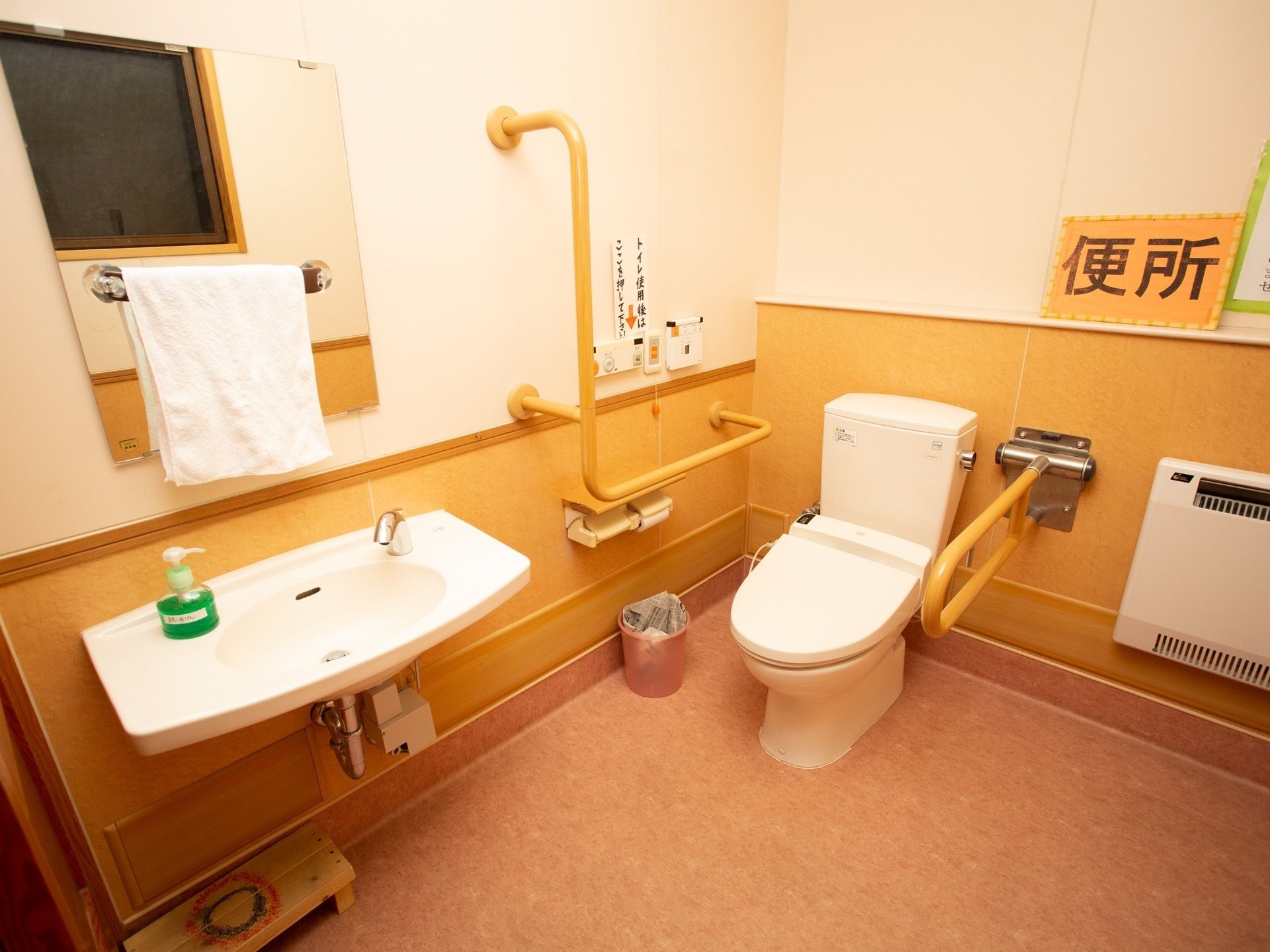 スペースに余裕があるトイレである。便器の両側に手すりが設置されている。独立した洗面台があり、しっかり手を洗うことができる。