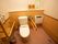 温水洗浄便座が採用された広いトイレである。操作ボタンが壁にあり、押しやすくなっている。便器の両側に可動式を含め手すりがある。