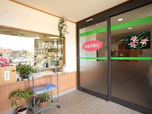 事務所が左手に、ユニット玄関が右手にある。「ひめさゆり」と書かれた横には花の写真も飾られている。