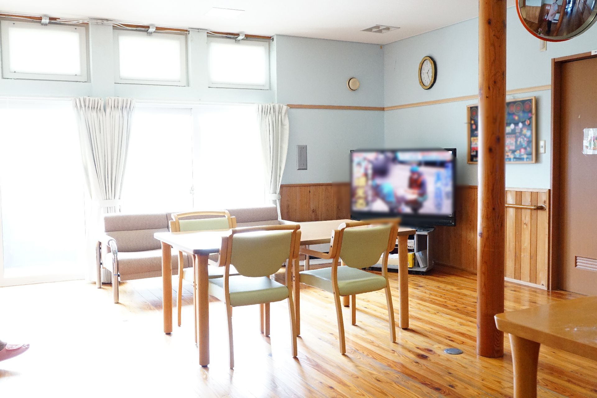 テレビが設置され、テーブルを挟んで椅子が多く置かれている共有スペース