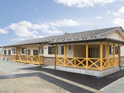 平屋建ての建物には瓦屋根が付き、玄関先には手すり付きのスロープが付いている。