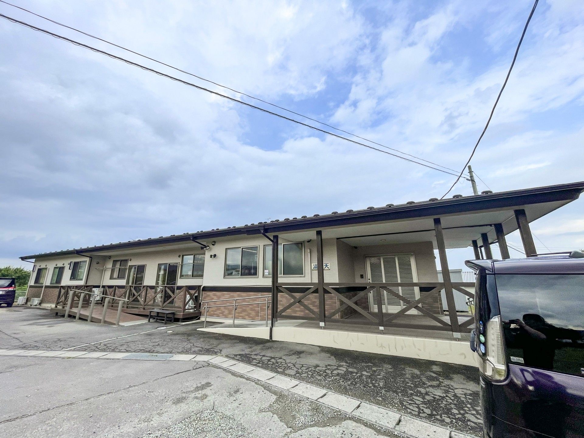 ウッドデッキが設置された平屋建ての建物には瓦屋根が付き、アットホームな雰囲気。