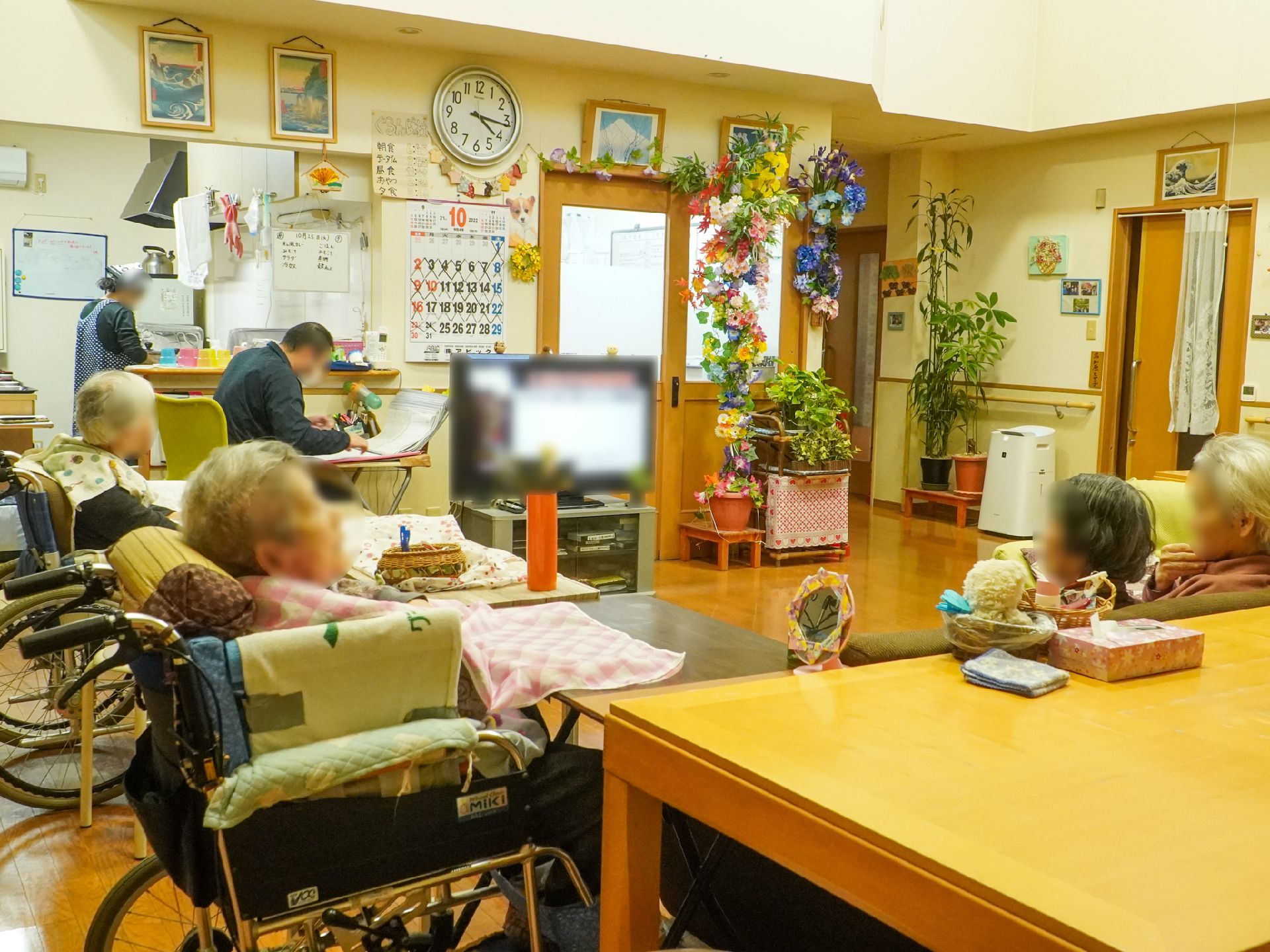 入居者が座ってテレビ鑑賞をしている様子の共有スペース