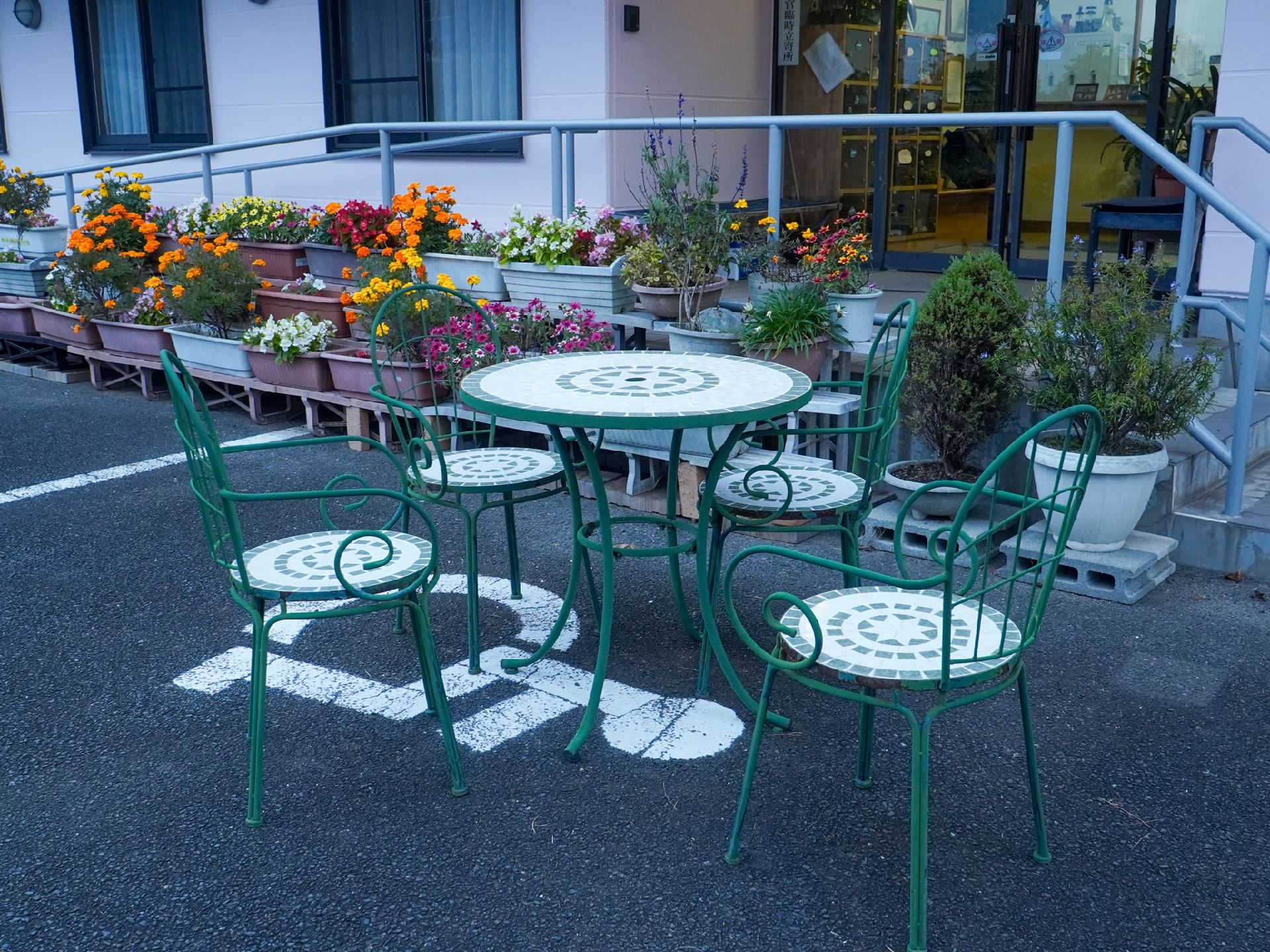 緑色のテーブルと椅子がおかれている外観