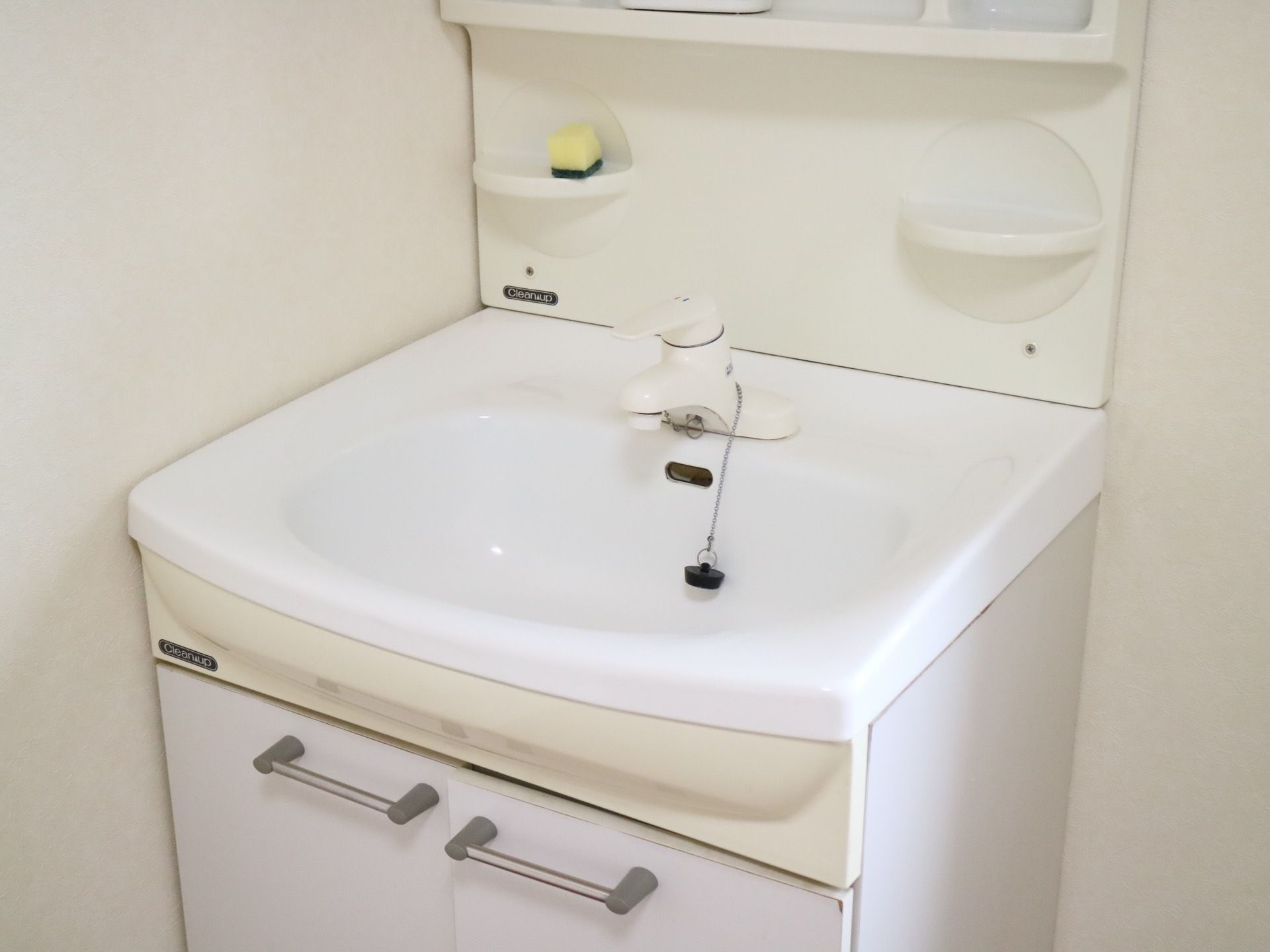 洗面台はレバーを上下することによって水量を調節する仕組みである。シンクの下には小物入れの収納がついている。
