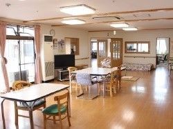 フローリング仕様のリビング。広めのスペースにいすと机が間を空けて並んでいる