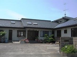 天気が良い日にグループホームひなたぼっこを写した写真。平屋建ての小さな建物