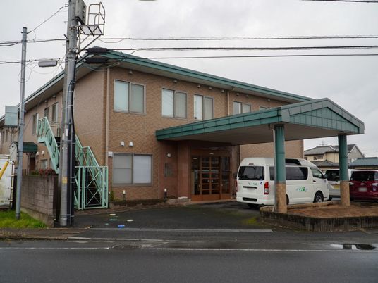 そよ風と書かれているワゴン車が停まっている2階建ての建物