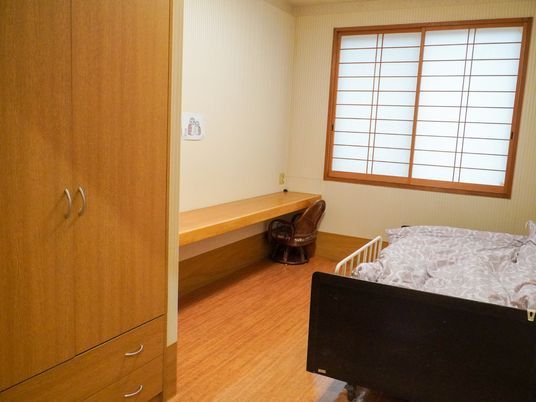 介護ベッドと洋式タンスがある和風の個室