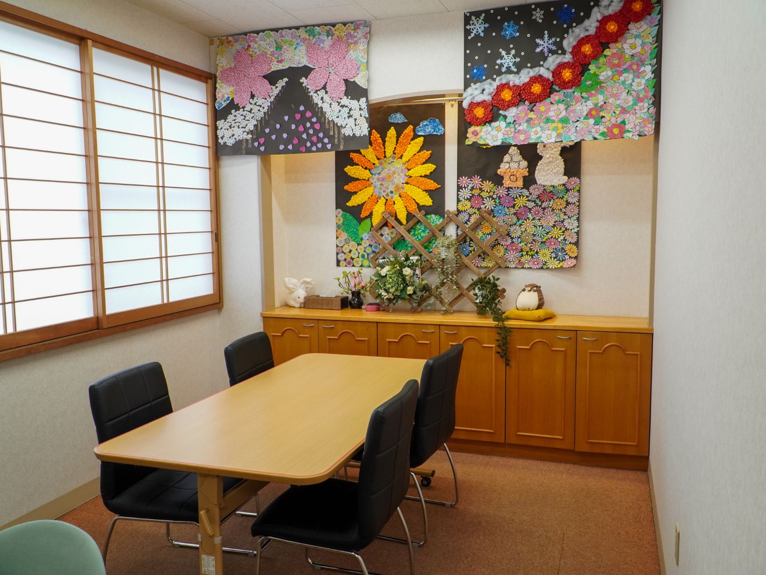 窓から日差しが降り注ぐ椅子とテーブルのある共有スペース