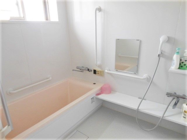 家庭と同じようなバスタブが設置された浴室には手すりやシャワーも付けられている。