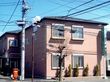日当たりの良い場所に建っている優しい色合いの建物。窓から日差しが差し込んでいる様子が分かる