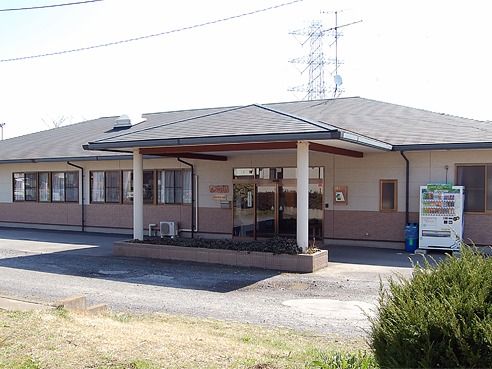 屋外には自動販売機が置かれ、平屋建ての建物の玄関部分には車寄せも付いている。