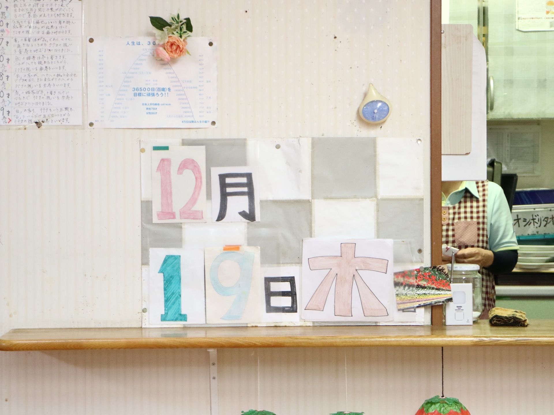 共有スペースには、キッチンが完備されている。そばの壁には、スタッフが手作りした日替わりカレンダーが掲示されている。