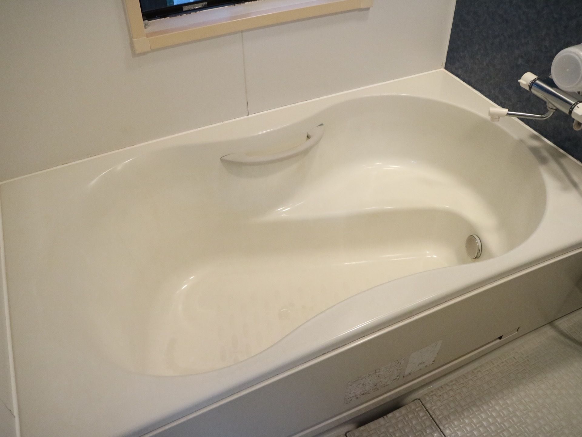 白と黒を基調としたシックな色合いの浴室。浴槽は広々としており、大人一人がゆったりとくつろげるスペースがある。