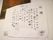 白色の紙に有名な歌の歌詞が手書きで書かれており、壁に飾られている。余白には里山の風景やタケノコが描かれている。