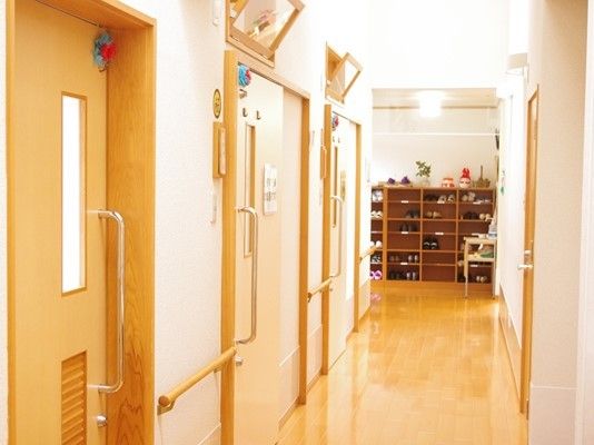 個室のドアが続く廊下の様子。奥のほうにげた箱がある施設エントランスがある