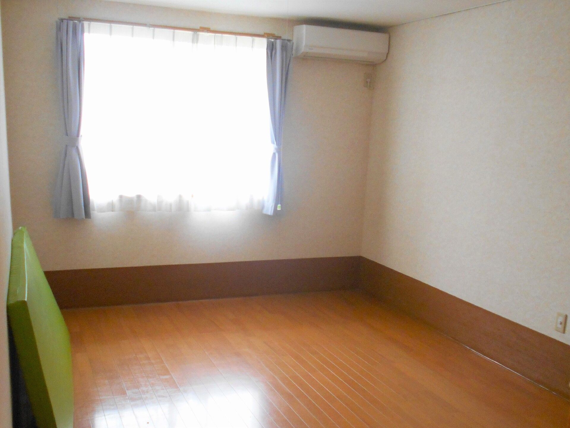 外出イベントを楽しむ車いすの男性入居者。女性スタッフが笑顔で付き添っている。