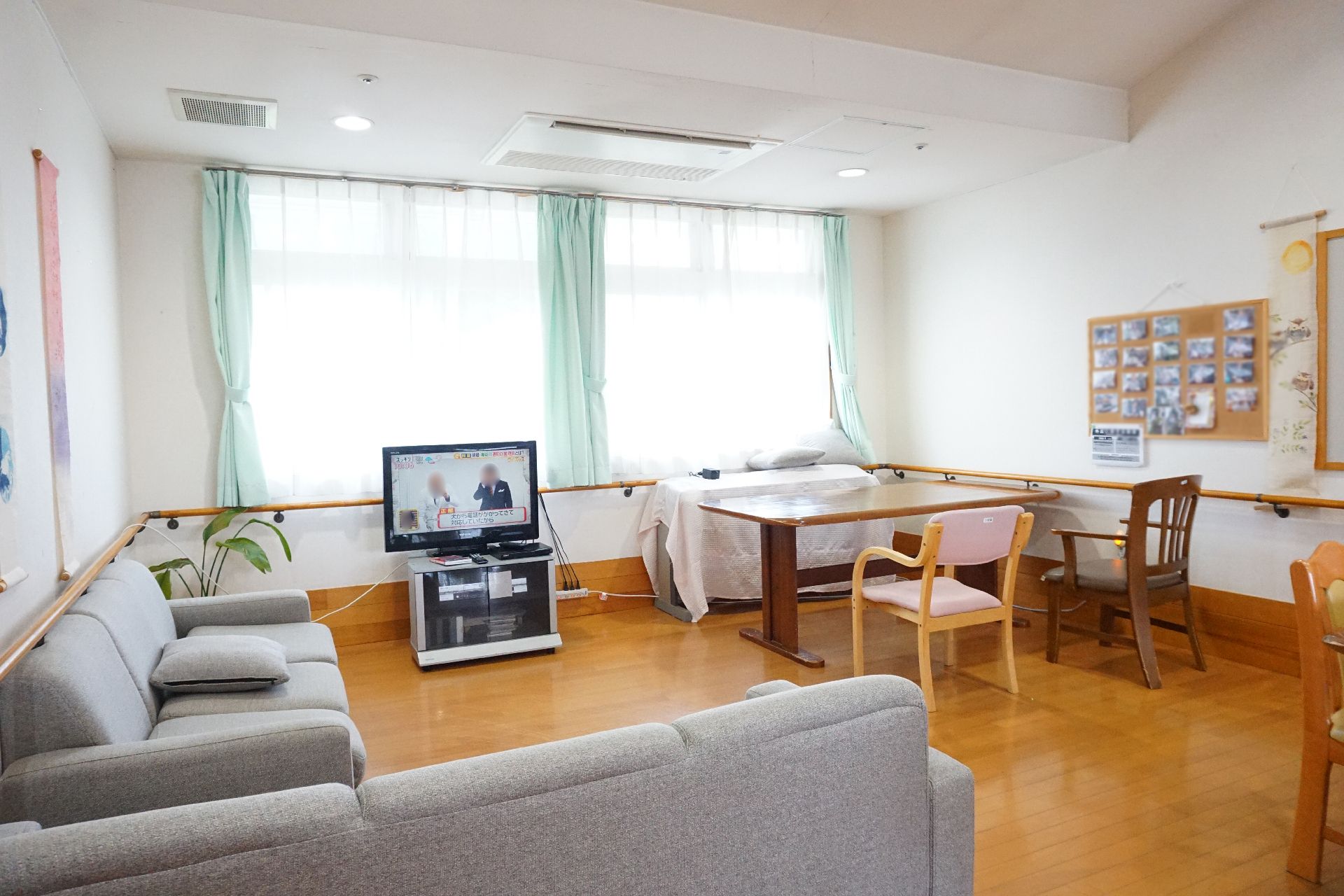 大きな窓から陽光が入り、テレビ、ソファーが設置されているリビング